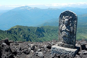 The stone Buddha statues along the crater wall create a solemn  atmosphere.