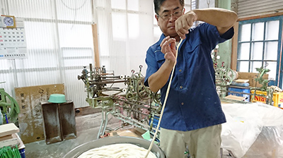 麺を確認する長尾製麺7代目長尾さんの写真