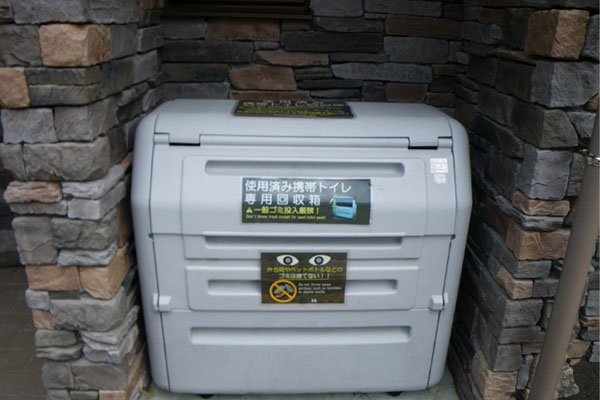 用过的便携式厕所的特别回收箱。附有严禁投入普通垃圾的标志。灰色塑料箱