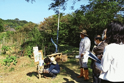 看板を設置しています。奥には木々が見えます。