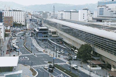 京都駅南口駅前をやや上から撮った写真です。近代的な駅舎、広い道路の他に、緑が見えます。