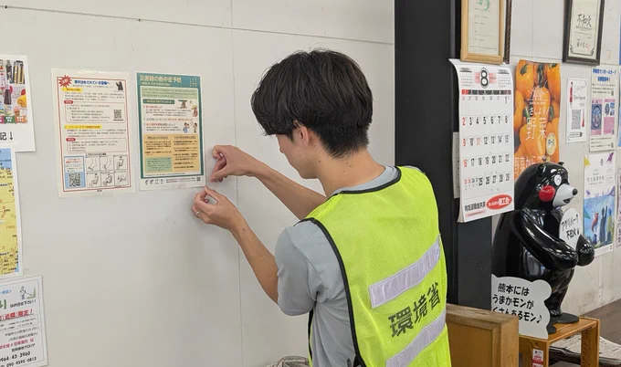 熱中症予防啓発リーフレットを貼る環境省職員