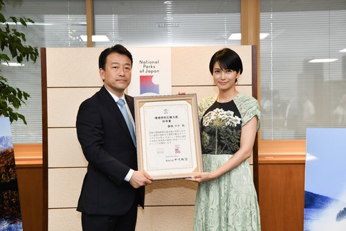 [Photo] Hiroyoshi Sasagawa, Parliamentary Vice-Minister of the Environment, and Ms. Ko Shibasaki pose for a photo with the power of attorney in their hands.