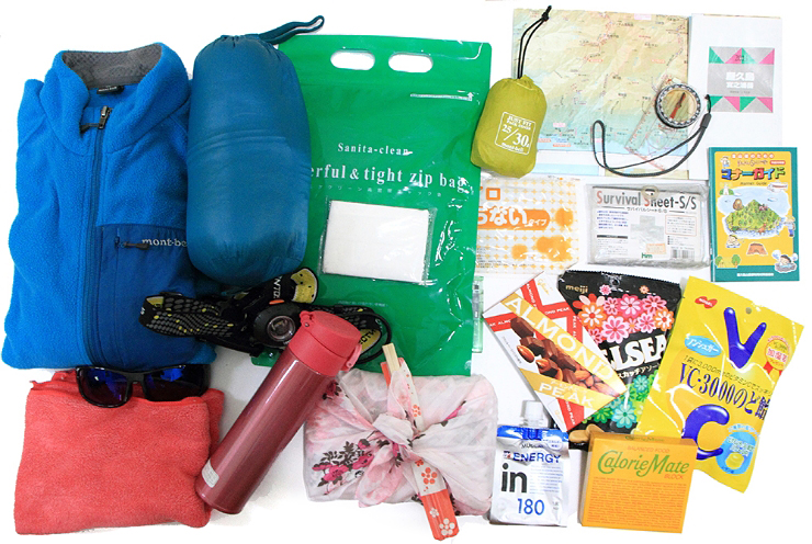 Typical contents of a winter  rucksack. Drinks and food, Yakushima Etiquette Guide, plastic bag toilet, warm clothing, headlamp