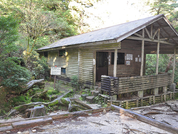 The Yodogawa Hut. Capacity of 40 people. The gable-roofed wooden structure is divided into two accommodation floors. The large open space in front of the hut.