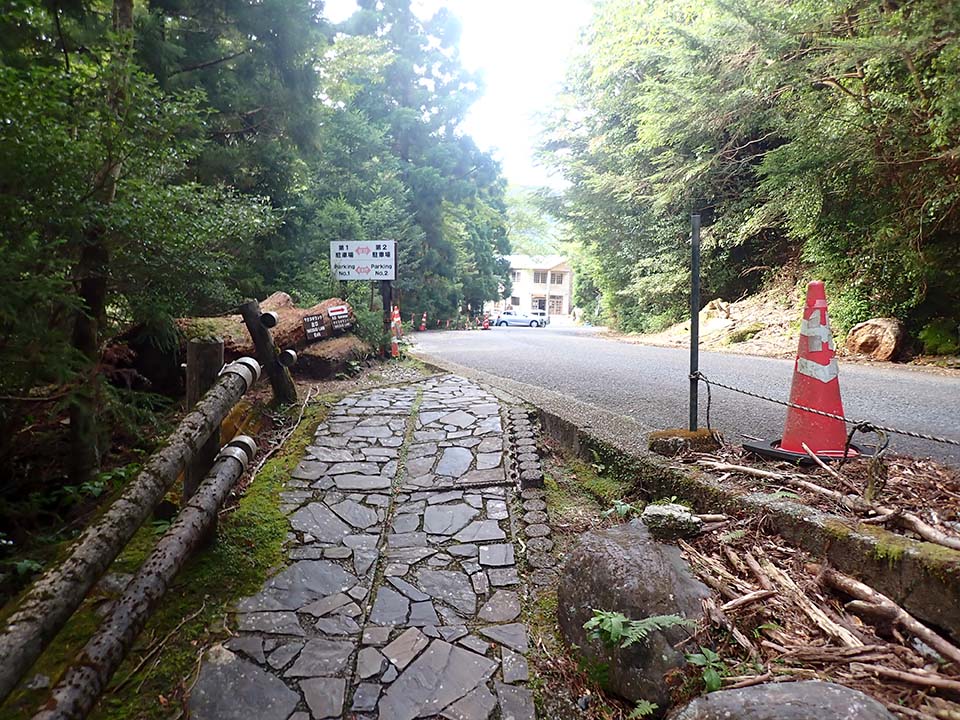 The Yakusugi Land Exit. The gently sloping stone-paved trail on the left leads to the road on the right.