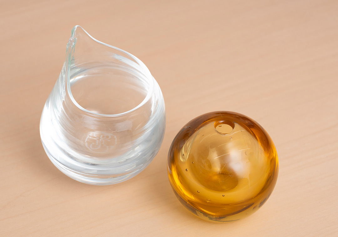 太陽光パネル由来のガラスをアップサイクルして制作した水差し（左）とペン立て（右）の試作品。