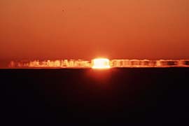 氷山の蜃気楼と太陽が重なると、太陽が四角に見えることがある。