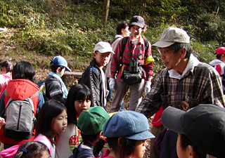 子どもたちに説明する田口代表（神於山保全くらぶ提供）