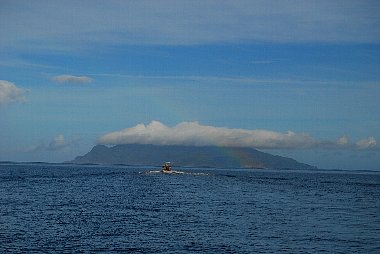 雄大な海を手前に、白い雲のかかった口永良部島が見える写真。