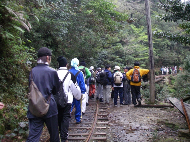 超混雑日のトロッコ道の様子。間隔なく、多くの人が列をつくって歩いています。列から外れた道で、立ち話をしているグループの人たちもいます。