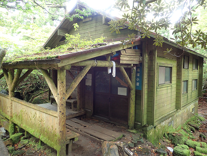 新高塚小屋の写真。収容人数は40人。三角屋根の木造構造で宿泊フロアは２段にわかれています。