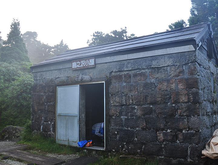鹿之沢小屋の写真。収容人数は20人。三角屋根の石造構造で宿泊フロアは２段にわかれています。