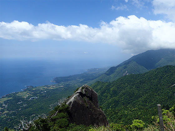 モッチョム岳山頂からの写真。屋久島南部の、海辺沿いにある集落や後背地に急激にせりあがる山々の様子が写っています。