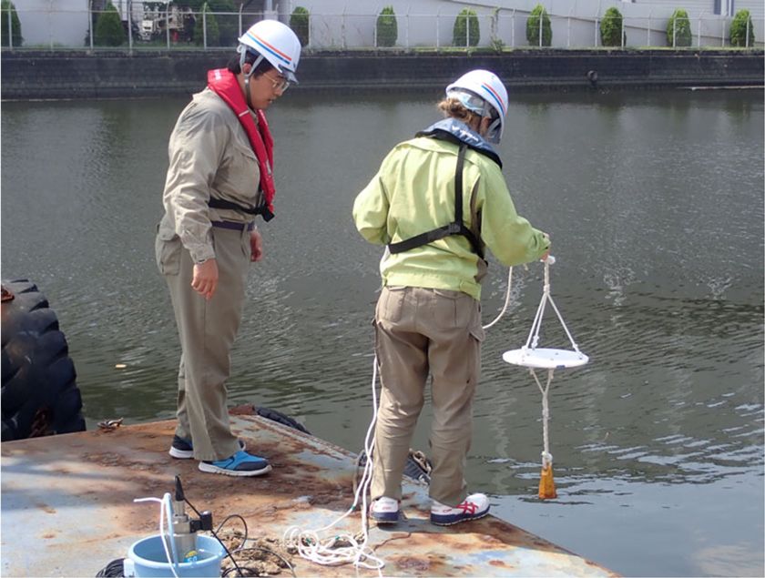 水質調査の器具を使用し、東京湾の水質調査を行う東亜建設工業株式会社の方々