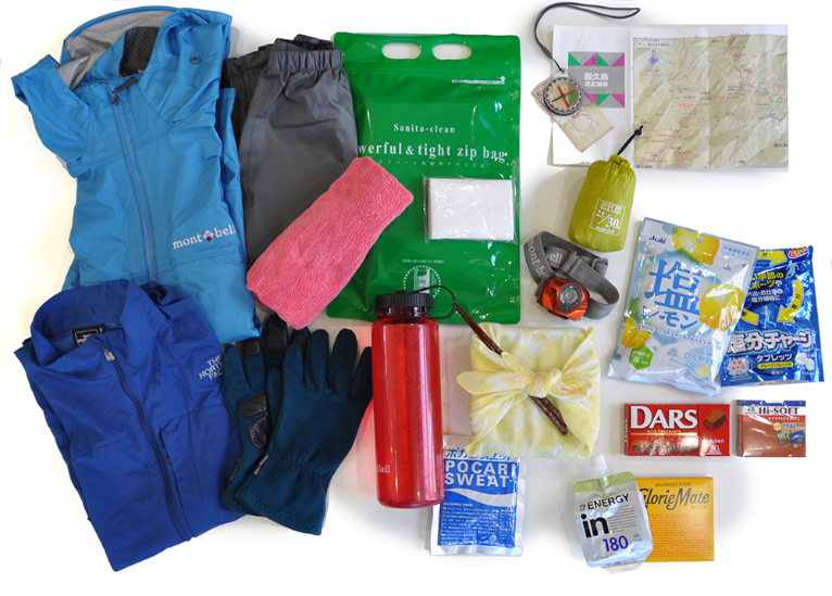 夏季背包內容物示例。裝運動飲料的水壺、包括應急食品的食物、雨衣（上下裝）、手套、登山地圖、背包罩、便攜式廁所、保暖衣物、頭燈。